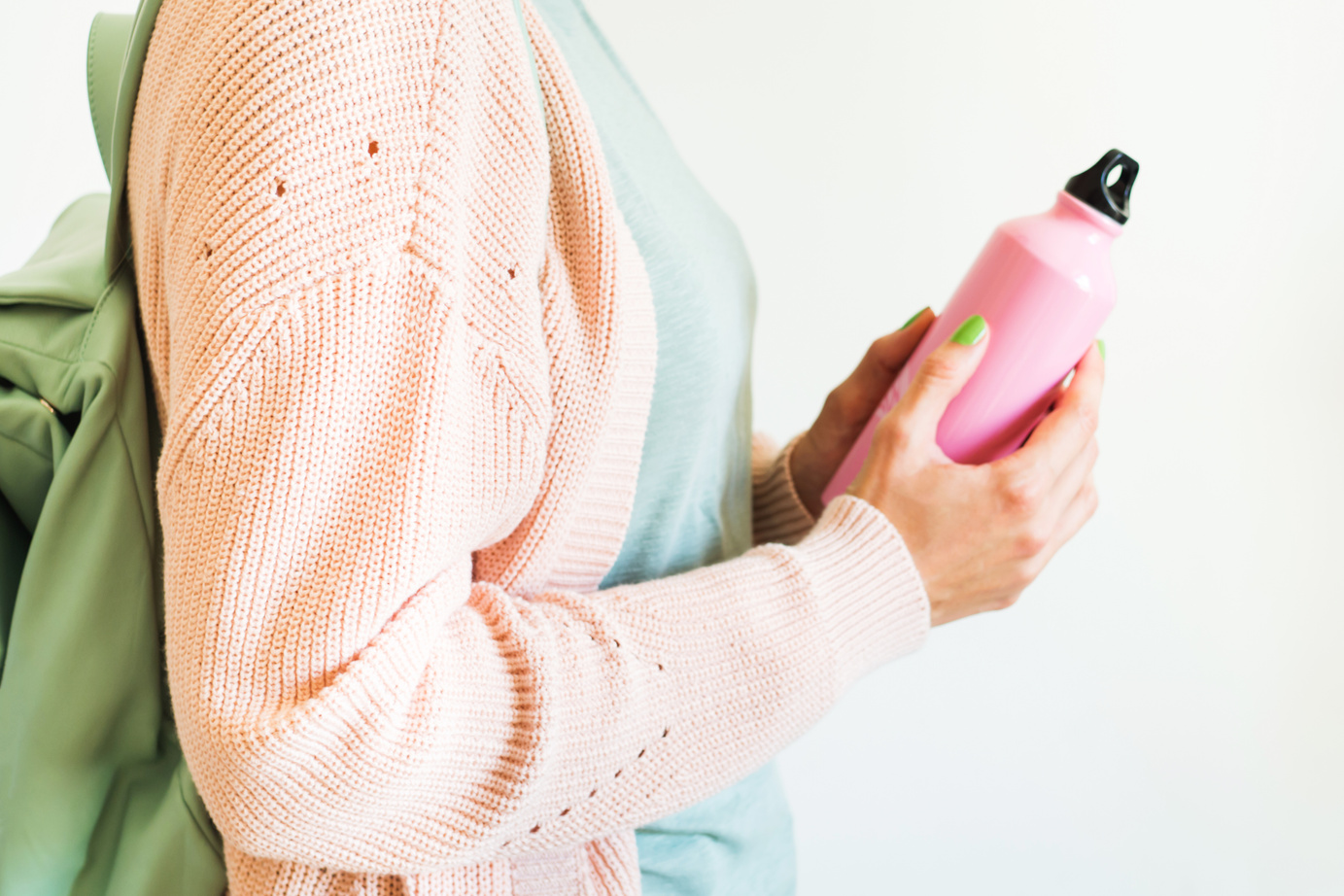 Woman holding pink reusable water bottle